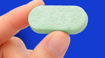 Hand holding a green tablet with 'Zero harsh chemicals' text and icons on a blue background